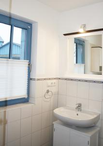 ein weißes Badezimmer mit Waschbecken und Fenster in der Unterkunft Ferienwohnung Urte in Putgarten , Kap Arkona Rügen in Putgarten + 37 Fotos