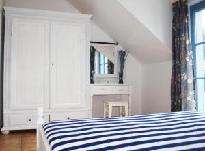 ein weißes Schlafzimmer mit einem Bett und einem Spiegel in der Unterkunft Ferienwohnung Urte in Putgarten , Kap Arkona Rügen in Putgarten