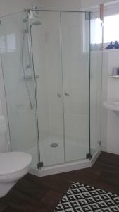een glazen douche in een badkamer met een toilet bij B&B ByBoukje in Eernewoude