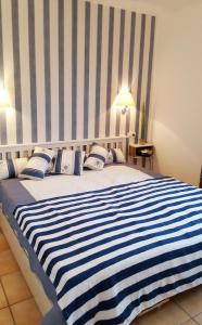 a large bed with a blue and white striped blanket at Ferienwohnung Finja in Putgarten, Kap Arkona Rügen in Putgarten