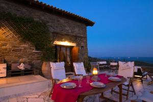- une table et des chaises sur la terrasse la nuit dans l'établissement Saronic Citadel, à Salamine