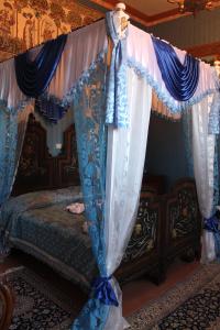 Arena的住宿－B&B Domenico Cesarelli，一间卧室配有天蓬床和蓝白色窗帘