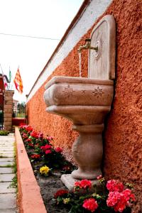 a stone sink sitting next to a wall with flowers at Villa Marogna in Alghero