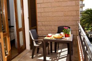 a table and chairs on a balcony with food on it at Villa Marogna in Alghero