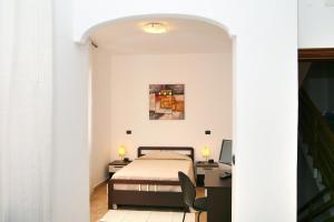 a bedroom with a bed and a desk and a computer at Villa Marogna in Alghero