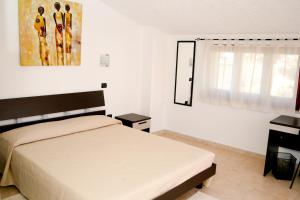 a bedroom with a bed and a window at Villa Marogna in Alghero