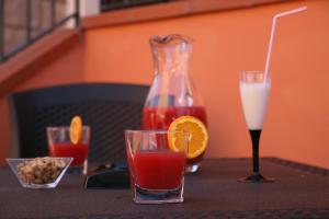 a table with two glasses and a vase with a drink at Villa Marogna in Alghero