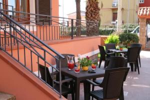 a patio with tables and chairs on a balcony at Villa Marogna in Alghero