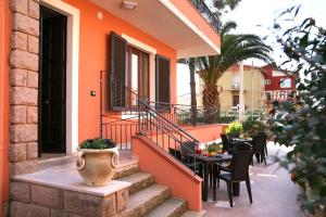 an orange house with tables and chairs on a patio at Villa Marogna in Alghero