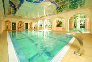 a large swimming pool in a building with a ceiling at Parkhotel in Bad Füssing
