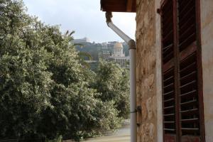 ein Rohr an der Seite eines Gebäudes mit Bäumen in der Unterkunft Rosa Guest House in Haifa