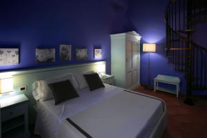 SalemiにあるBaglio Borgesatiの紫の壁のベッドルーム1室(白い大型ベッド1台付)