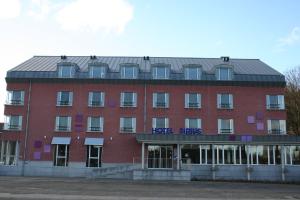 un bâtiment en brique rouge avec un panneau. dans l'établissement Hotel Sirius, à Huy