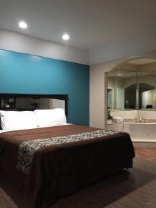 1 dormitorio con 1 cama grande y bañera en Scottish Inns & Suites Timber Creek, Houston, TX, en Houston