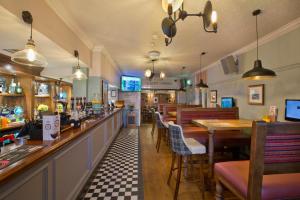 un restaurante con bar y algunas mesas y sillas en The George Inn, en Selby