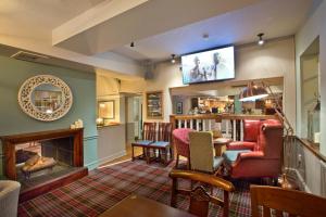 a living room with a fireplace and a tv at The George Inn in Selby