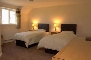 duas camas num quarto com duas lâmpadas nas mesas em The New Inn Hotel em Stratford-upon-Avon