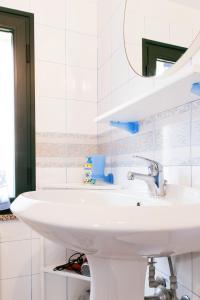 Un baño con un lavabo blanco y un espejo. en Appartamento Monte Oro, en Santa Maria Navarrese 15 fotos más