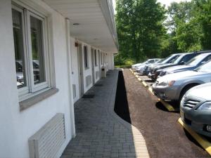 una fila de coches estacionados al lado de un edificio en Fair Motel en Upper Saddle River