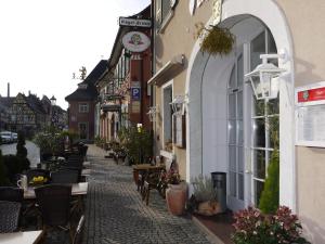 une rue avec des tables et des chaises et une horloge dans un bâtiment dans l'établissement Hotel Engel, à Endingen am Kaiserstuhl