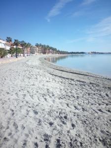 una playa de arena con huellas en la arena en Apartamentos Espejo, en Los Alcázares