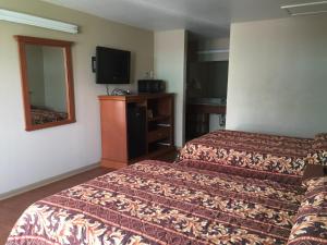 Pokój hotelowy z 2 łóżkami i lustrem w obiekcie Garden Inn Motel w mieście San Antonio
