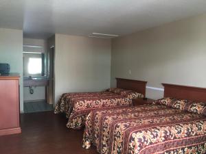 a hotel room with two beds and a window at Garden Inn Motel in San Antonio