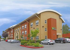 un edificio con coches estacionados en un estacionamiento en Extended Stay America Suites - San Jose - Santa Clara en San José