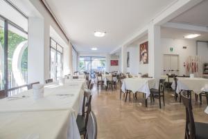 a dining room with white tables and chairs at Hotel Hollywood Convenzionato Aquafan in Riccione