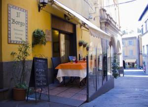 阿夸彭登泰的住宿－IL Borgo Ristorante Pizzeria Camere，前面有一张桌子的黄色建筑