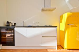 a kitchen with white cabinets and a yellow refrigerator at Fantastic Bright Penthouse in Amsterdam