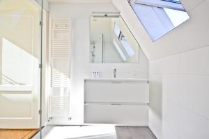 ein Bad mit einem Waschbecken und einem Spiegel in der Unterkunft Fantastic Bright Penthouse in Amsterdam