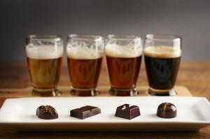 four glasses of beer and chocolate on a plate at Apartment Nathalie in Comines