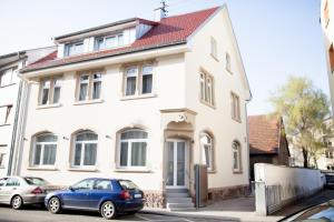 een blauwe auto geparkeerd voor een wit huis bij Apartment Haus Heidelberg in Heidelberg