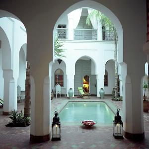 a courtyard with a swimming pool in a building at Riad Herougui in Marrakesh