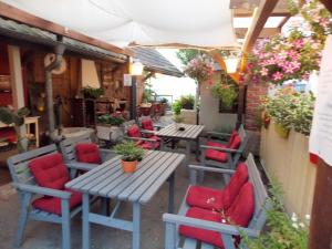 un patio al aire libre con mesas y sillas rojas en Ferienwohnung 'Alte Schmiede', en Teningen