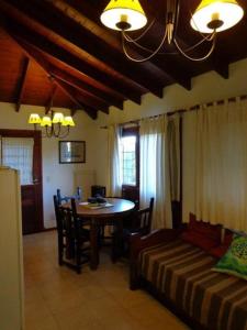 Una sala de estar con una mesa y una cama. en Villa Olimpia Cabañas, en Villa Gesell