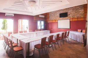 uma sala de conferências com uma mesa longa e cadeiras em Triple Hill Hotel em Weija