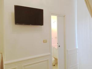 TV de pantalla plana en la pared de una habitación en i principi.bb, en Foggia