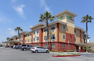 a hotel with cars parked in a parking lot at Extended Stay America Suites - Los Angeles - Carson in Carson