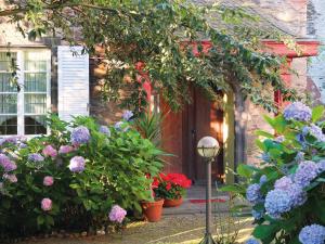 a garden with flowers in front of a house at Pension Marienhof in Kobern-Gondorf