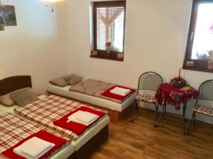 a room with two beds and a table and two chairs at Privat Pani Danka in Dolný Kubín