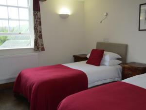 a bed room with two beds and a window at The Kilcot Inn in Newent