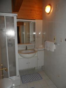 a white bathroom with a sink and a shower at Burggräflerhof in Lana