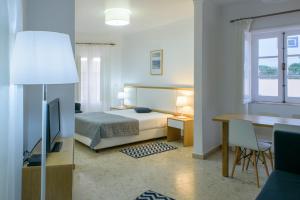 a bedroom with a bed and a desk with a desk at Apartamentos Dunamar in Vila Nova de Milfontes