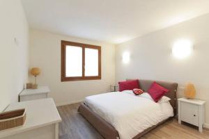 a bedroom with a bed with red and white pillows at A Casa Di Giada in Refrontolo