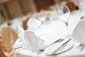 a white table with wine glasses and silverware at Riu Plaza The Gresham Dublin in Dublin