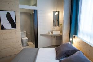 圣塞瓦斯蒂安Talo Urban Rooms的一间带床的卧室和一间带水槽的浴室 更多37张照片