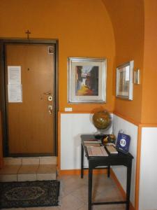 ein Zimmer mit einem Tisch neben einer Tür mit einem Kreuz in der Unterkunft My House Suite in Monopoli