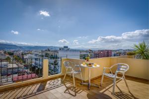 balcón con mesa, sillas y vistas en Nefeli Hotel, en La Canea